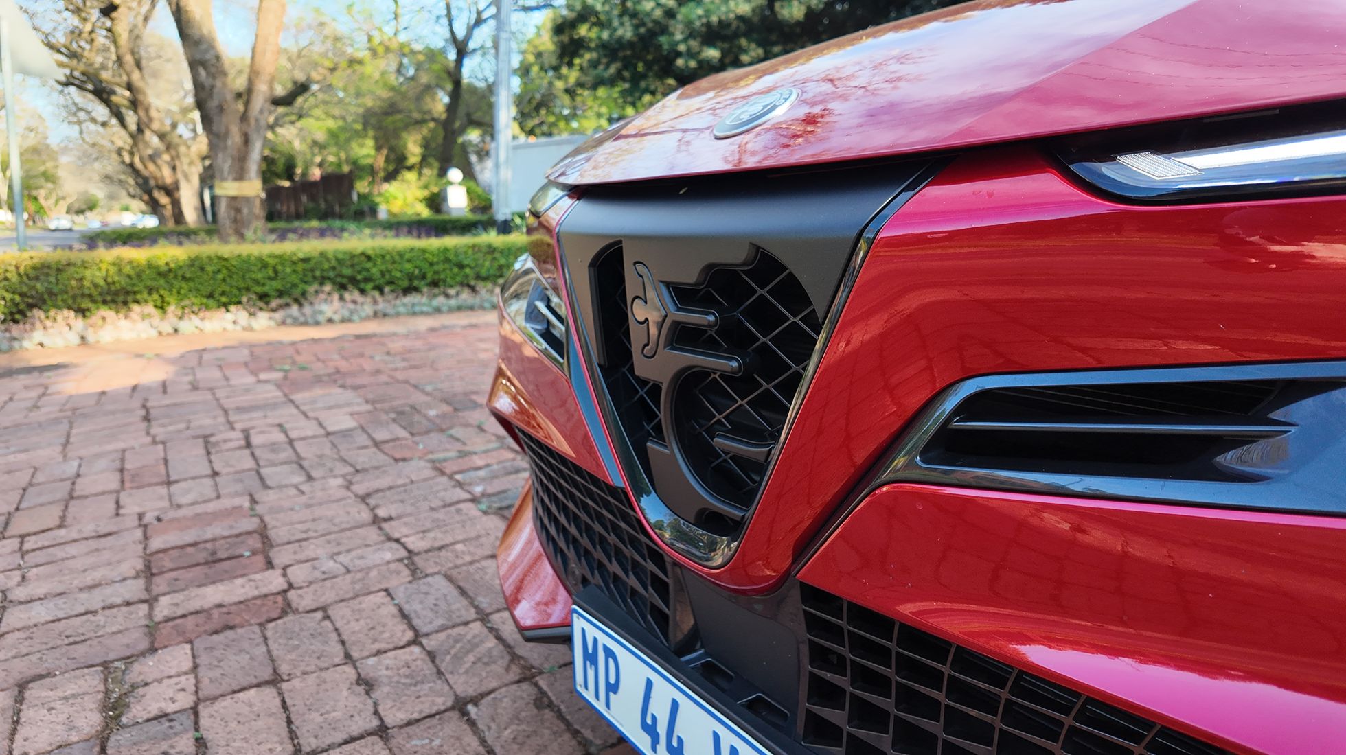 Close-up of the Alfa Romeo Junior Elettrica Veloce front grille featuring the iconic Alfa Romeo serpent emblem.