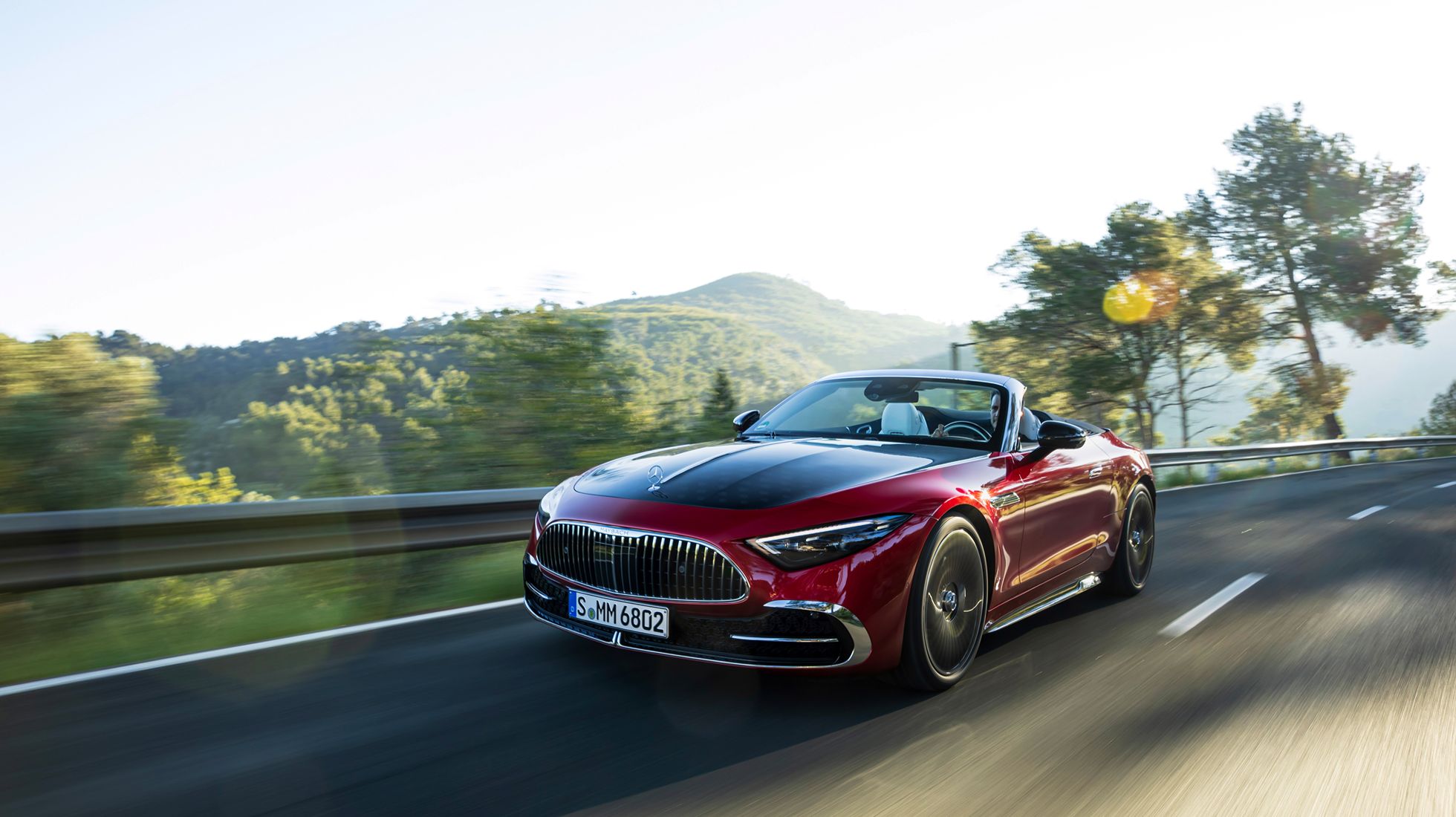 Mercedes-Maybach SL 680 Monogram Series driving along a winding mountain road with its convertible roof lowered.